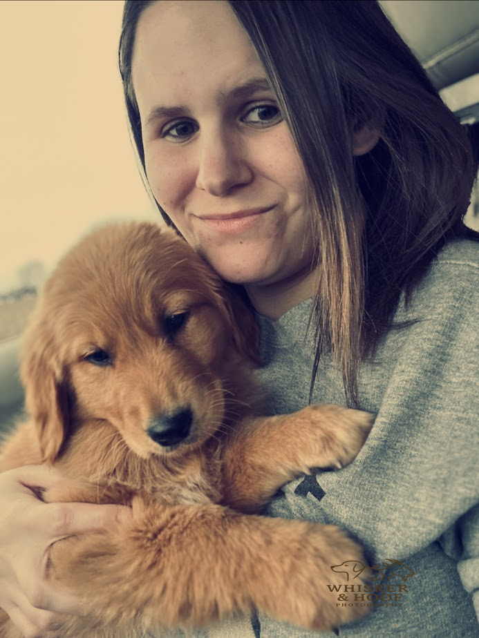 Desiree holding a golden retriever puppy